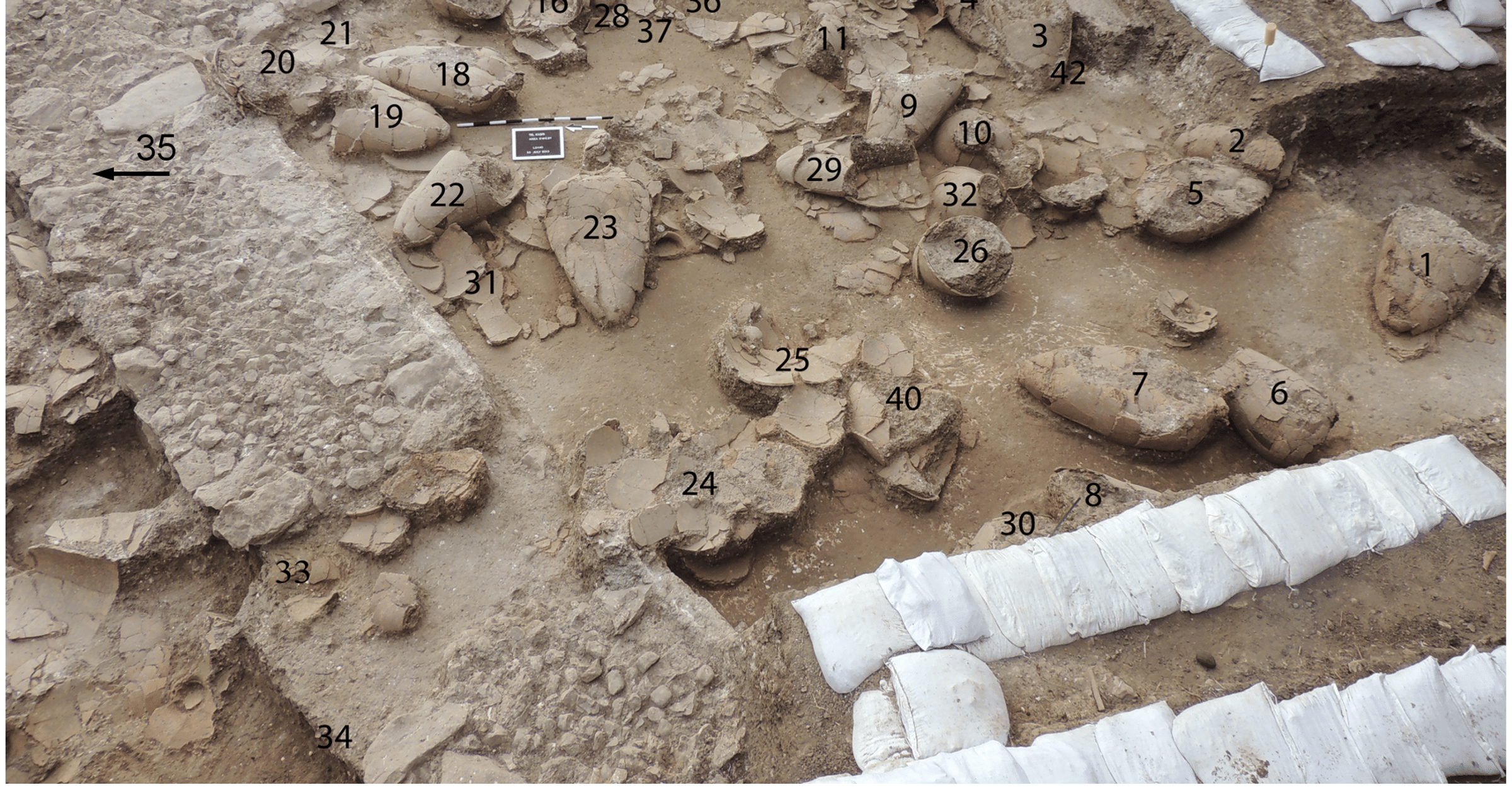 2013 image of labelled wine jars in first Tel Kabri wine cellar towards the southeast - World History Encyclopedia